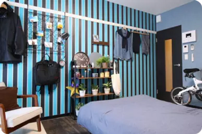 使用藍色和黑色條紋壁紙的男性房間
